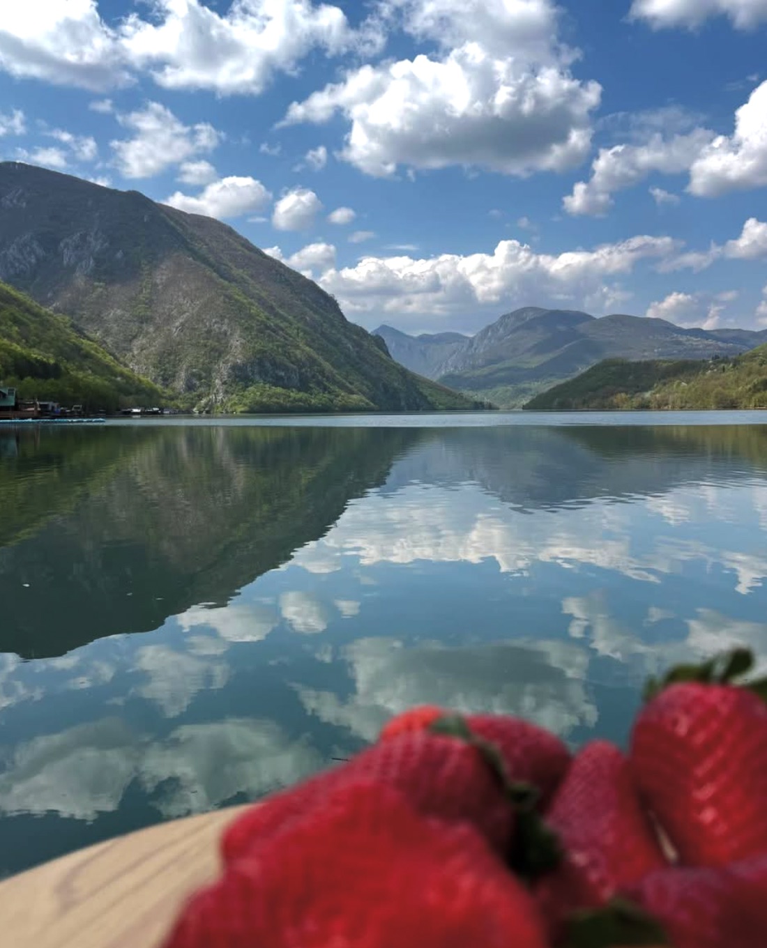 Panorama jezera Perućac sa odrazom oblaka u mirnoj vodi